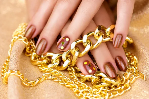Altın Benekli Kahverengi Manikürlü Kadın Parmakları Altın Bir Arka Planda — Stok fotoğraf