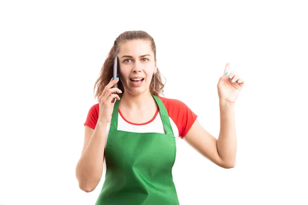 年轻女性超市或超市员工用智能手机拨打电话 用食指指着白色背景的手指 — 图库照片