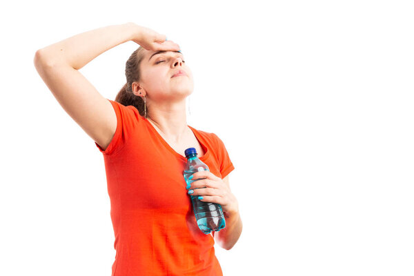 Young woman having medical problem because of heat touching forehead and holding bottle of water as heatstroke concept isolated on white background