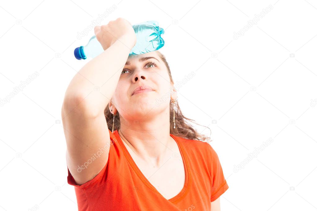 Young woman feeling hot and cooling with water bottle touching her forehead as high summer heat concept isolated on white background