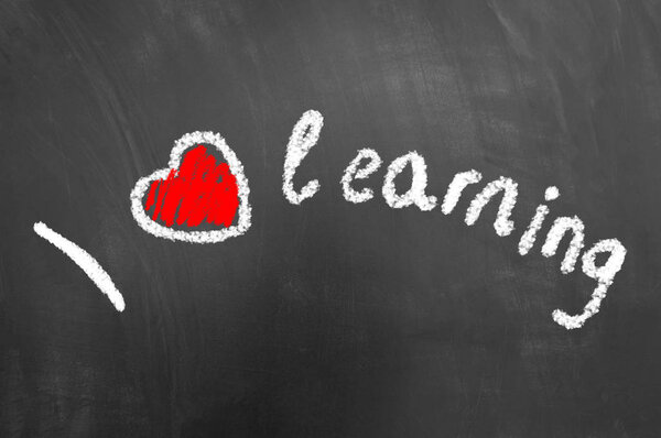 I love learning chalk text on school blackboard or chalkboard with heart drawing as knowledge studying education concept