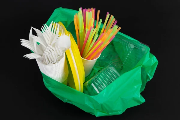 Plastik atık tehlike ekoloji kavramı tam çöp torbası ve renkli tek çatal bardak tabak güveç kutuları siyah arka plan üzerine izole payet kullanın