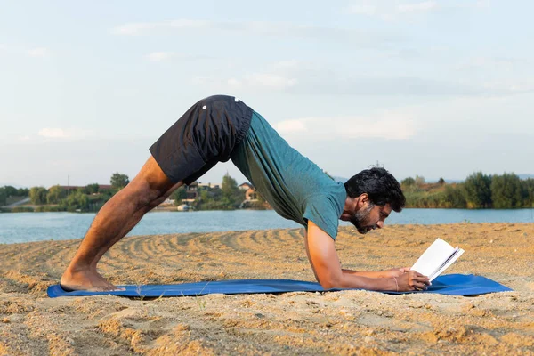 印度瑜伽在海滩 Reasinf 在向下的狗位置与自然背景 — 图库照片