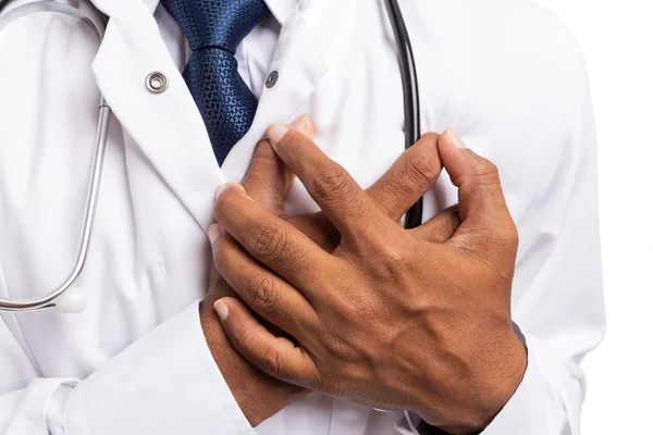 Male medic touching heart as cardiac problems concept close-up isolated on white background