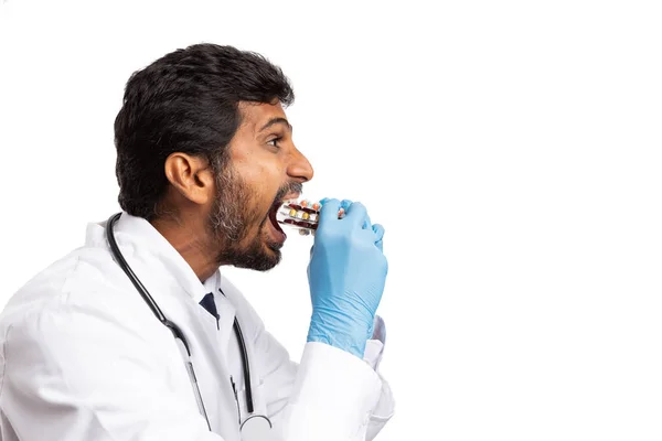 印度男医生吃药水泡作为成瘾或夸张的概念查出在白色背景 — 图库照片