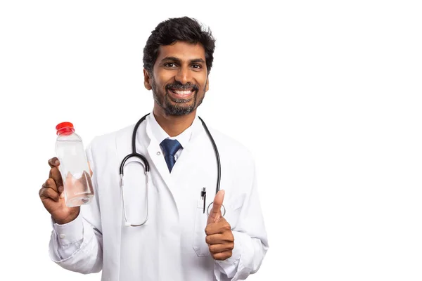 フレンドリーなインドの男性医師笑顔と親指でプラスチック製のボトルを押しながら同意するか 白い背景で隔離のジェスチャーをお勧めします — ストック写真