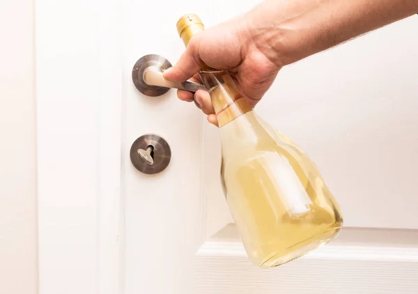 Osoby Otwierającej Drewniane Białe Drzwi Przez Metalowy Uchwyt Butelką Wina — Zdjęcie stockowe