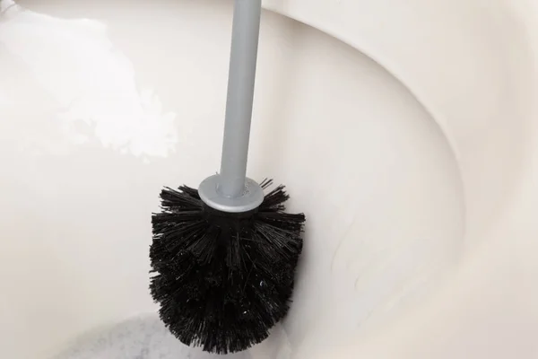 黑色马桶刷用于清洗内的白瓷 — 图库照片