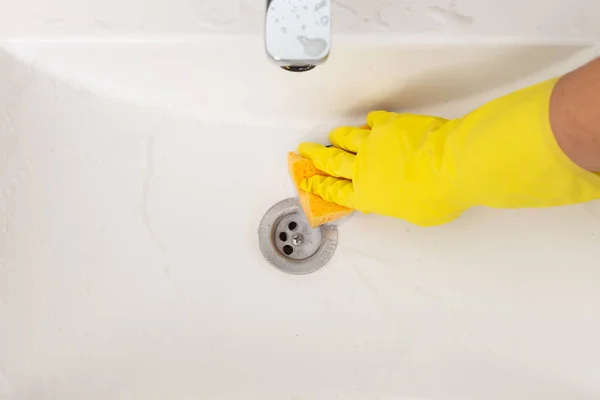 人清洁瓷器浴室用海绵和戴黄色手套用泡沫眨眼 — 图库照片