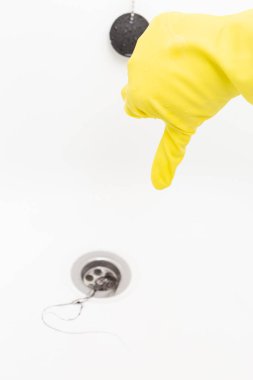 Başparmak aşağı hareketi su drenaj tıkanma saç için sevmemek gibi sarı lastik eldiven gösteren kişi