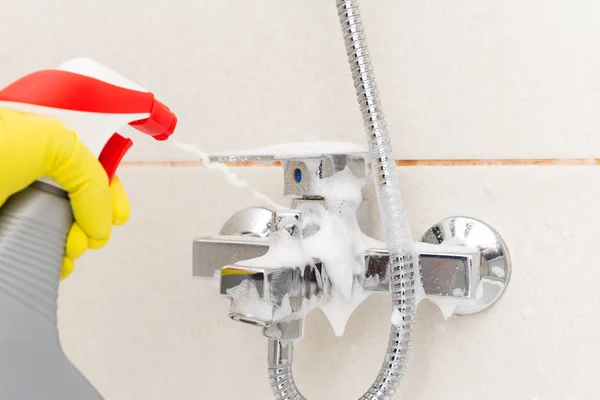 人喷洒金属水龙头从淋浴穿着卫生橡胶手套作为浴室清洁的概念 — 图库照片