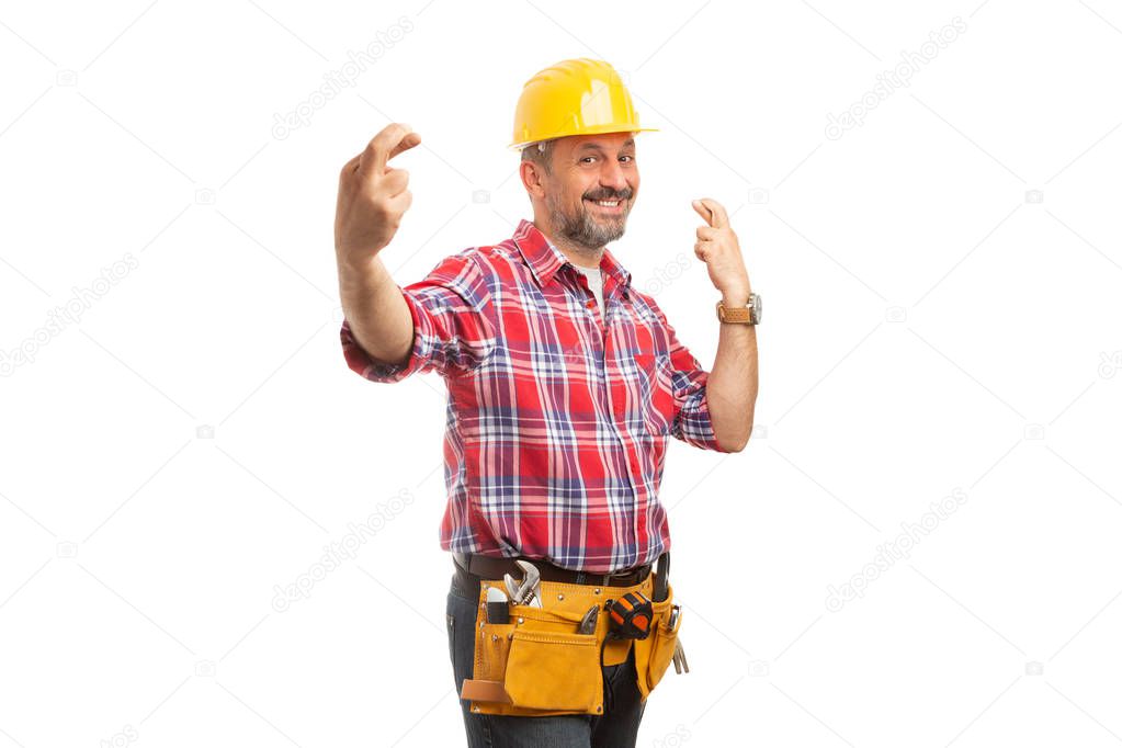 Smiling constructor with fingers crossed at both hands as good luck concept isolated on white studio background