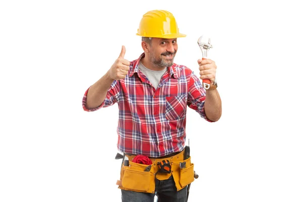 微笑的建设者男子拿着扳手和拇指像在白色背景上孤立的手势 — 图库照片