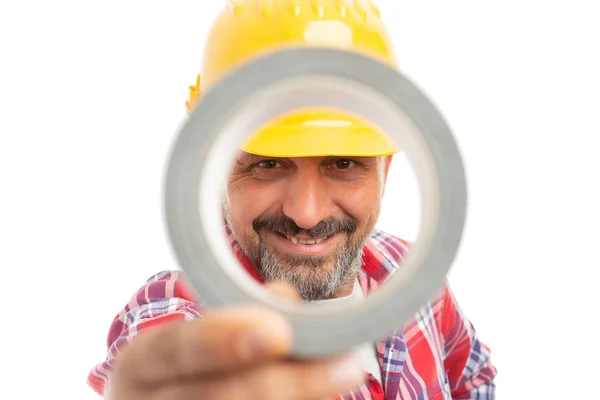 Construtor Sorridente Olhando Através Fita Adesiva Isolada Fundo Estúdio Branco — Fotografia de Stock