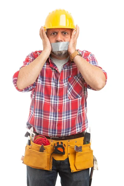 Scared male constructor with grey duct tape on mouth as silence concept isolated on white studio background