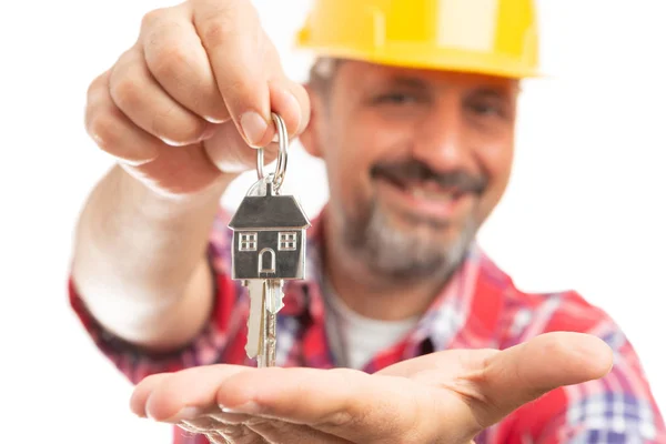 Builder smiling as presenting house door key on palm close-up with selective focus isolated on white background