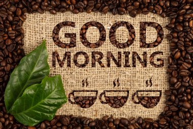 Günaydın çuval bezi üzerinde yazılı metin dokulu arka plan altında üç kahve fincanı kavrulmuş fasulye çerçeve içinde bir çizim ile