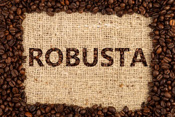 Robusta coffee type spelled inside frame made out of scattered beans on brown textured background