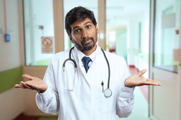 混乱してインド男性医師または病院の玄関にあるヤシの木と無知の表情やしぐさを作ってメディック — ストック写真