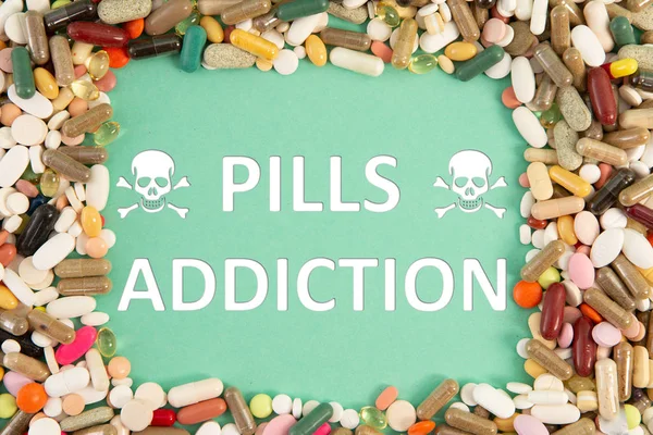 Pills addiction text and health hazard skulls symbol with colourful medicine frame on blue background