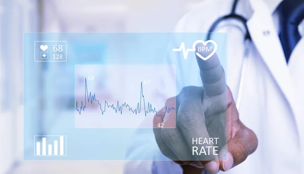 Close-up indian male cardiology medic touching heart symbol on invisible display with index finger as futuristic medicine concept