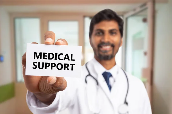 Doctor presenting medical support text on car — Stock Photo, Image