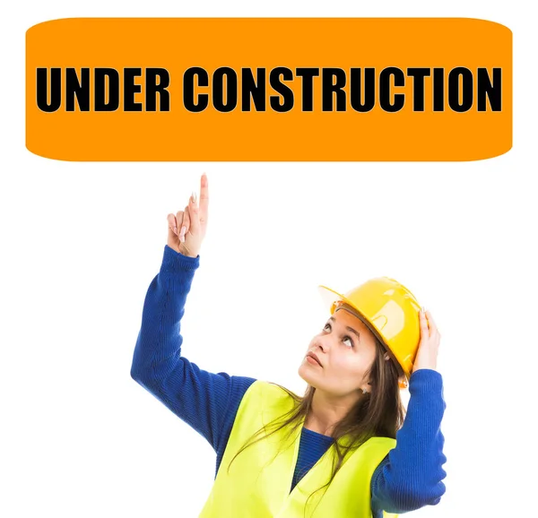 Женщина-строитель, указывающая на строящийся сиг — стоковое фото