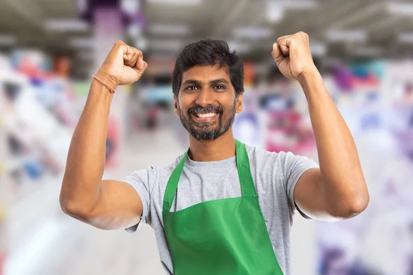 Supermarket employee holding fists up as cheerful gestur — Stock Photo, Image