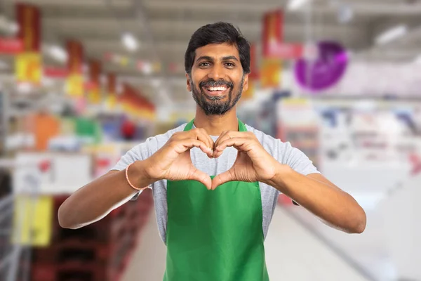 Man aan het werk bij supermarkt maken hart gebaar met hand — Stockfoto