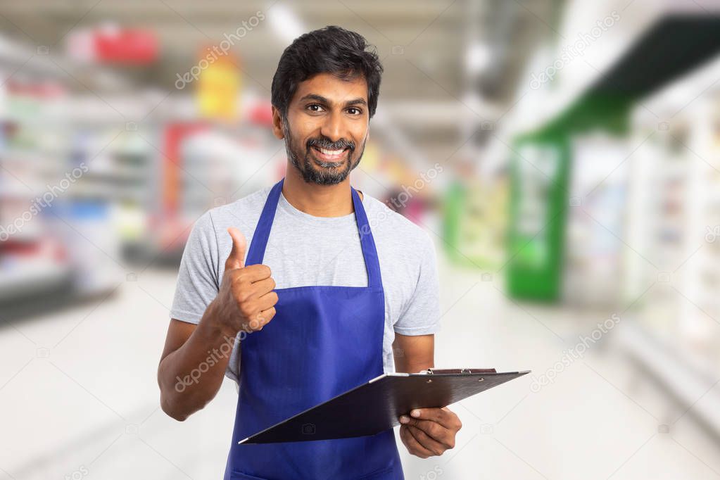 Worker at hypermarket showing thumb-up holding clipboar