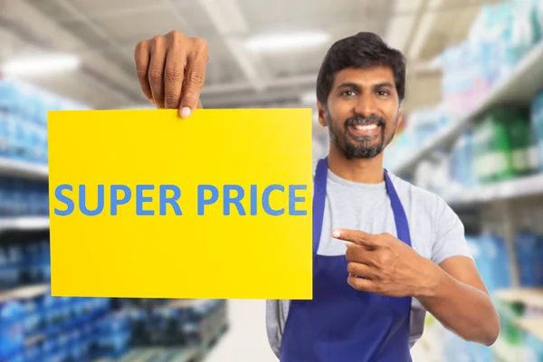 Supermarket worker pointing at super price pape