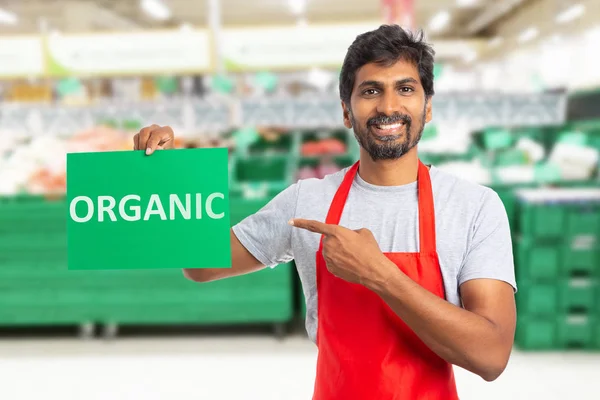 Man working at grocery store presenting organic text on pape — Stock Photo, Image