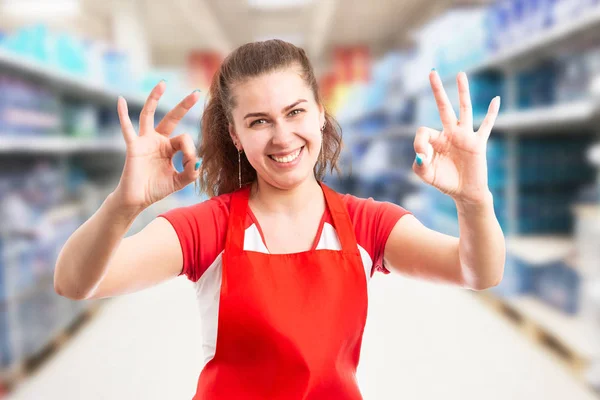 Female employee at hypermarket making okay gestur — Stock Photo, Image