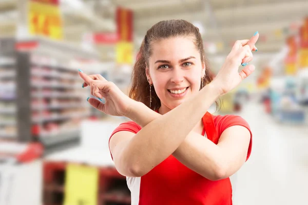 Hypermarket worker wishing good luck with crossed fingers and ar