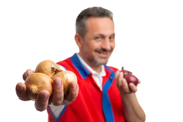 Supermarket employee showing onions closeup — Stock Photo, Image