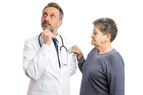 Paciente poniendo dinero en el bolsillo del médico — Foto de Stock