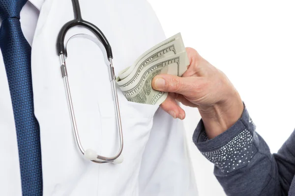 Nahaufnahme einer Frau, die Geld in die Hosentasche eines Arztes steckt — Stockfoto