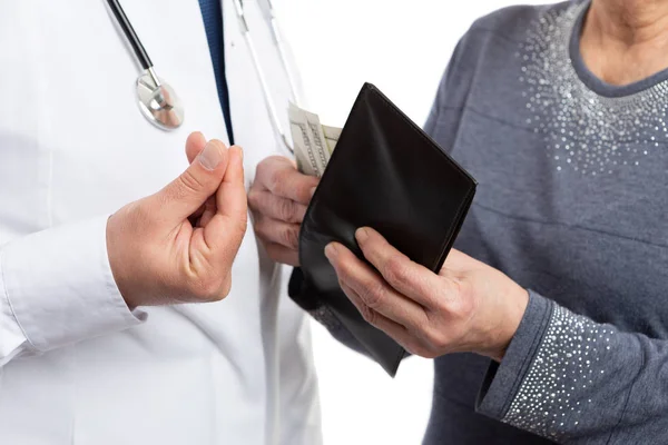 Nahaufnahme eines Patienten, der Geld in Brieftasche steckt, und eines korrupten Arztes — Stockfoto
