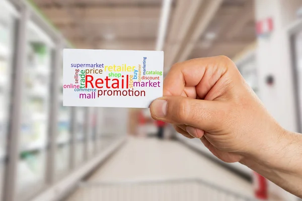 Hypermarket employee presenting card with big retail text