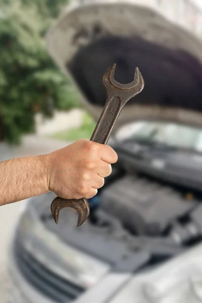 Homem segurando chave como conceito de reparação — Fotografia de Stock