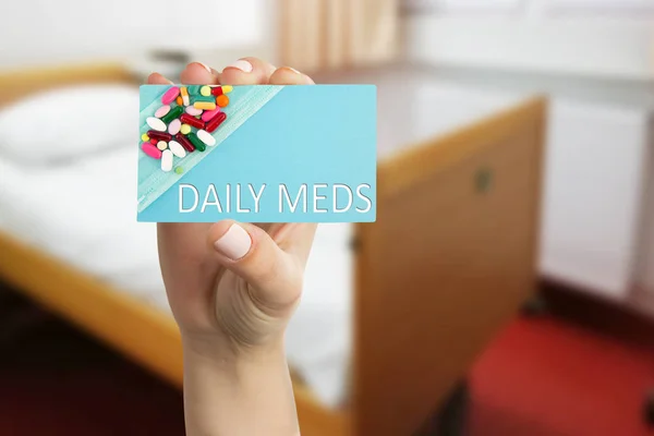 Medic presenting daily meds text on card — Stock Photo, Image