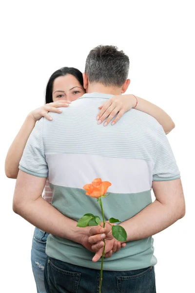 バラを隠す男と抱き合うカップル — ストック写真