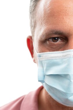 Grip salgınını önlemek için cerrahi maske takan bir adamın yarım portresi.