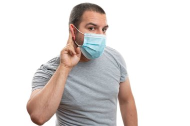 Kulağına dokunan yetişkin bir adamın işaret parmağıyla yaptığı jestler, beyaz telif uzayında izole edilmiş 19 grip salgınından korunmak için burun ve ağzını kapatıyordu.