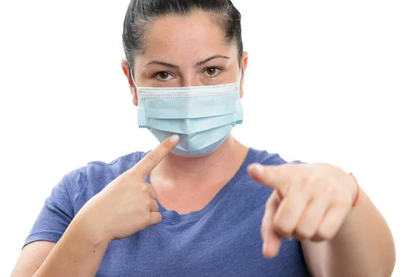 女性模特儿把食指指向一次性医疗或外科口罩 你就能进行筛查 以防止感染从白种人背景分离出来的流感病毒 — 图库照片