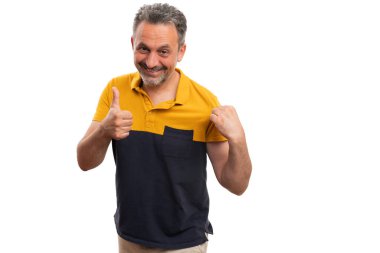 Gülümseyen, gülümseyen, sarı ve siyah tişörtlü, kabul edilebilir bir jest yapan, beyaz arka planda izole edilmiş sıradan bir yaz kıyafeti konsepti olan neşeli bir adam.