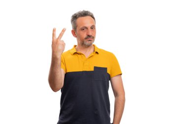 Yetişkin bir adam, el parmaklarıyla iki ya da iki jest yaparak günlük yaz kıyafetleri giyip beyaz arka planda izole edilmiş siyah tişört giyerek konsept sayıyor.