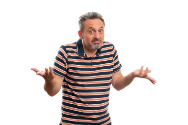 Kafası karışık erkek model, beyaz arka planda izole edilmiş günlük çizgili yaz tarzı tişört giyerek omuz silkip soru soruyor.