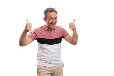 Neşeli erkek modeli, beyaz stüdyo arka planında izole edilmiş günlük renkli tişört giyen boş telif alanı ile aynı jesti gösteriyor.