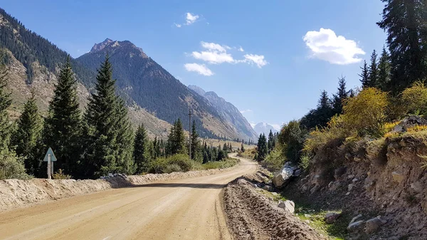 Een Onverharde Weg Naar Bergen Onder Blauwe Hemel Met Wolken — Stockfoto